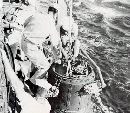 A photo of Navy crewmen picking up Glenn's capsule