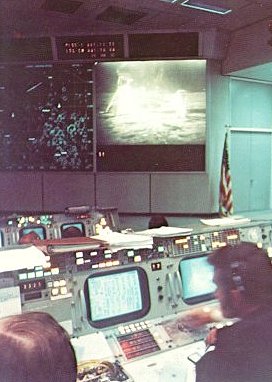 A photo of a television monitor at the front of Mission Operations Control Room