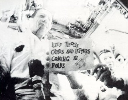A photo of Apollo 7 Commander,Wally Schirra,holding a gag card